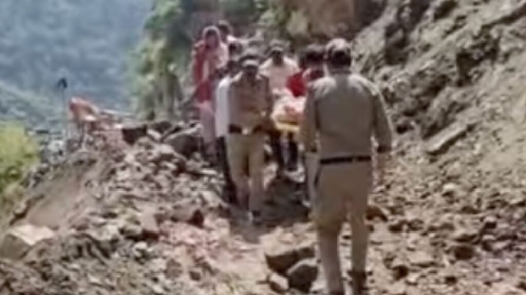 यातायात पुलिस गर्भवती महिला को स्ट्रेचर से पार करवाती हुई