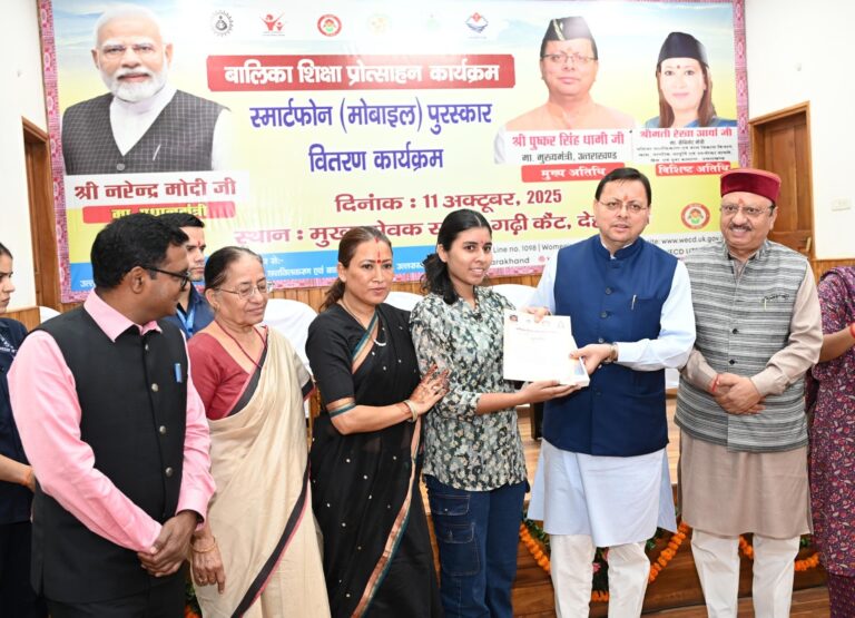 मुख्यमंत्री पुष्कर सिंह धामी अंतरराष्ट्रीय बालिका दिवस पर मेधावी छात्राओं को स्मार्टफोन देते हुए।