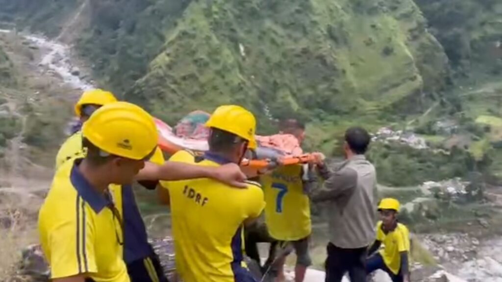 मुनस्यारी गोल्फा गांव में घायल महिला को स्ट्रेचर से ले जाती SDRF टीम