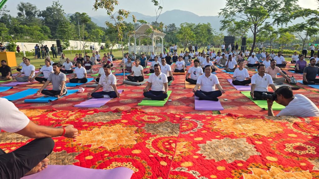 देहरादून के एमडीडीए सिटी फॉरेस्ट पार्क में अंतरराष्ट्रीय योग दिवस 2026 पर मुख्य सचिव आनंद बर्धन और 1000 से अधिक लोगों द्वारा सामूहिक योग करते हुए।