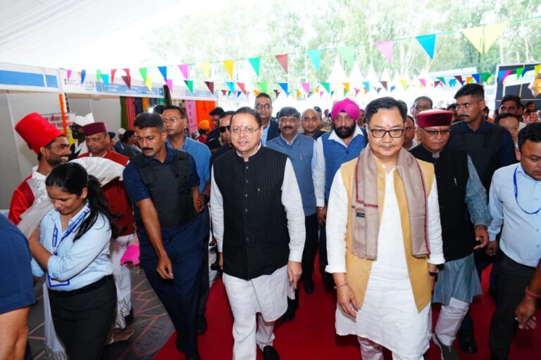 देहरादून के परेड ग्राउंड में लोक संवर्धन पर्व 2026 का उद्घाटन करते मुख्यमंत्री पुष्कर सिंह धामी और केंद्रीय मंत्री किरेन रिजिजू, साथ में पौधरोपण और हस्तशिल्प प्रदर्शनी का अवलोकन।