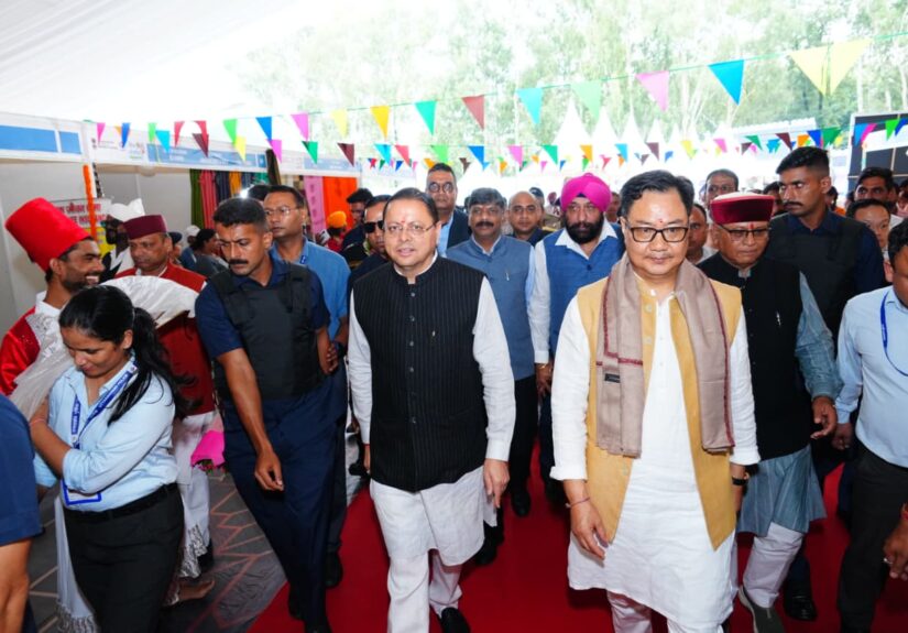देहरादून के परेड ग्राउंड में लोक संवर्धन पर्व 2026 का उद्घाटन करते मुख्यमंत्री पुष्कर सिंह धामी और केंद्रीय मंत्री किरेन रिजिजू, साथ में पौधरोपण और हस्तशिल्प प्रदर्शनी का अवलोकन।